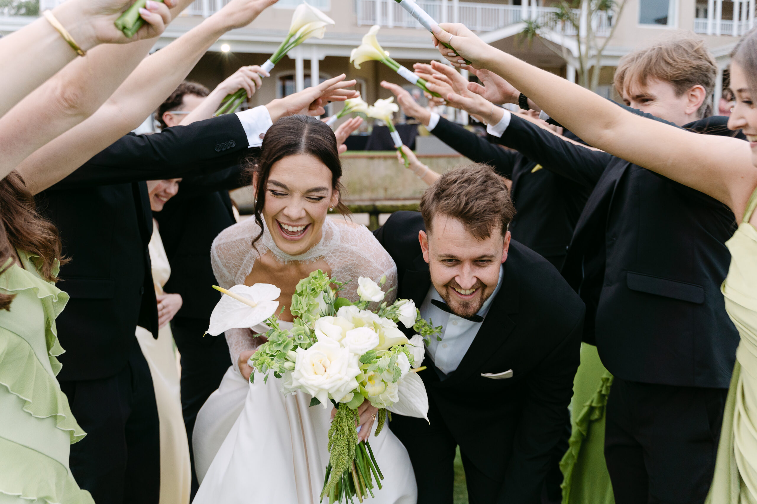 Kealan and Andrew laughing with their wedding party at Prince's Grant